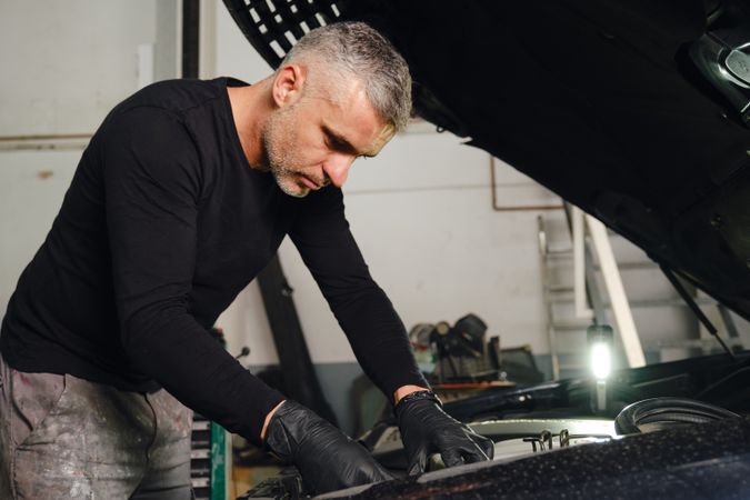Mechanic fixing car engine in garage