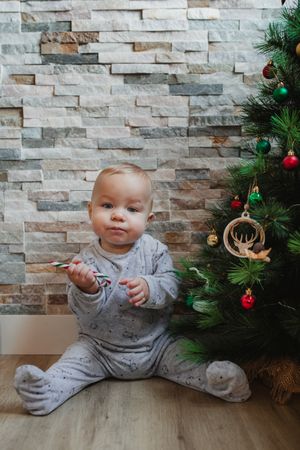 Cute baby playing with Christmas tree baubles