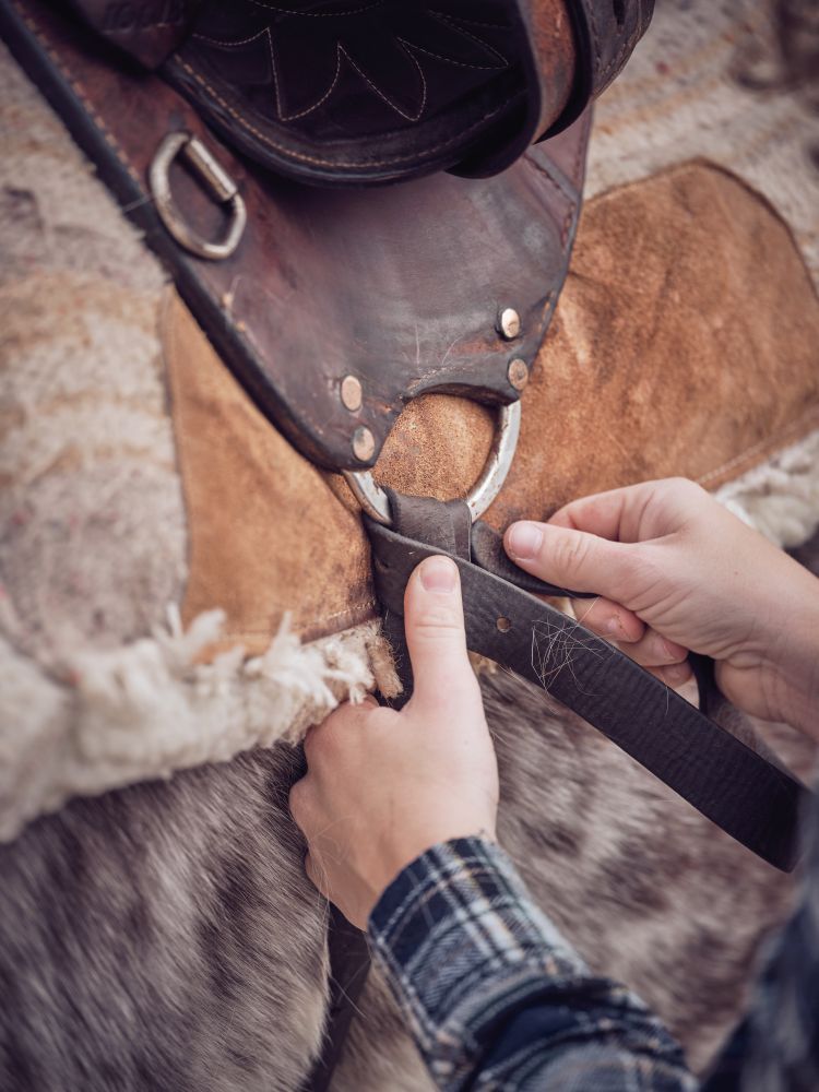 Anonymous rider tying knot on girth
