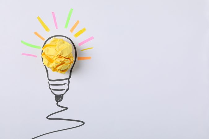 Drawn light bulb and paper ball on light background. Good idea concept