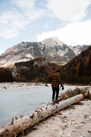 Man delighting in views near lake and mountains