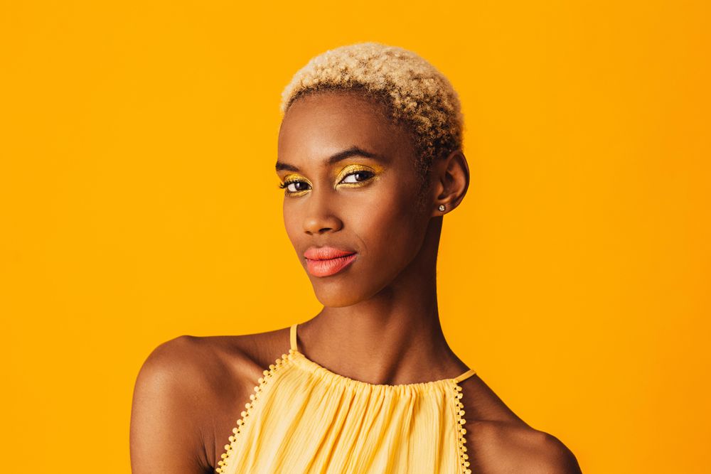 Black woman with short blonde hair looking at camera