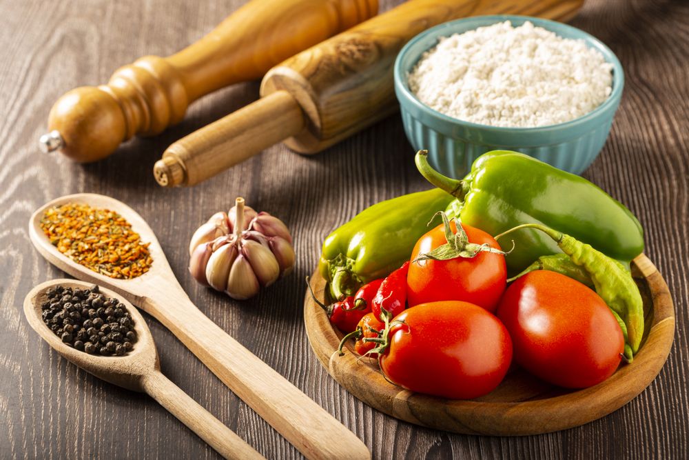 Wooden table with ingredients for pizza.