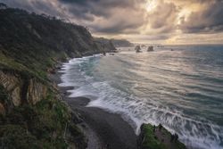 Beautiful bay around rocks and cloudy sunset