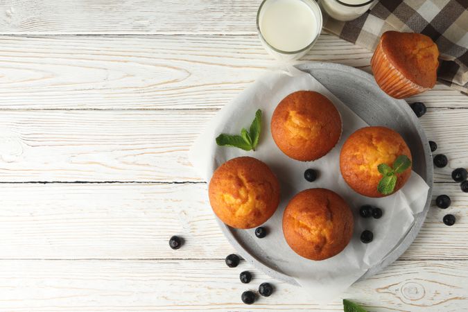 Composition with muffins and milk on wooden background