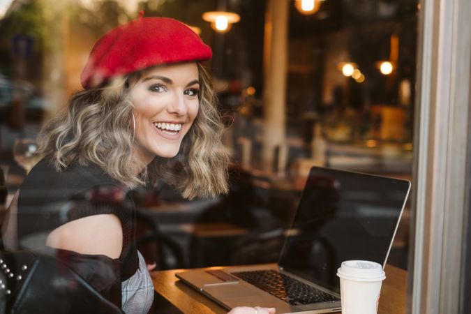 Dreamy woman using laptop in cafe