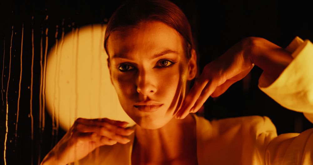 Portrait of a Young Woman Performing a Modern Dance Choreography on a Dark Stage with Creative Background with Raindrops.