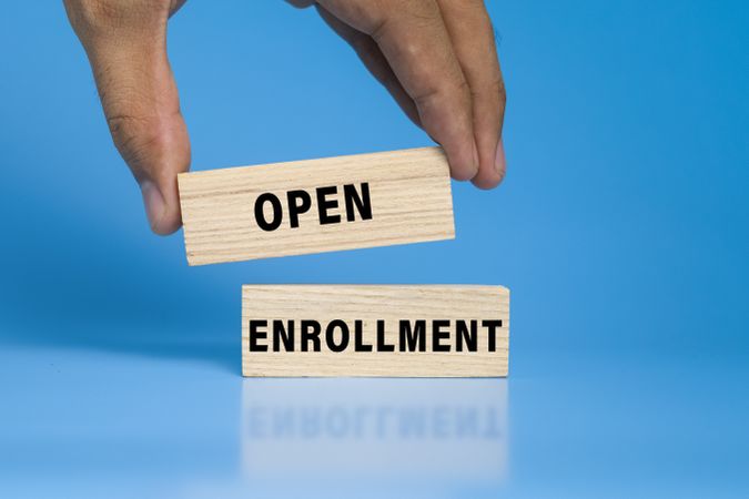 open enrollment words on wooden blocks isolated on blue background