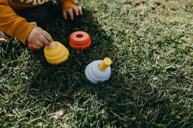 Child playing with toys in the grass