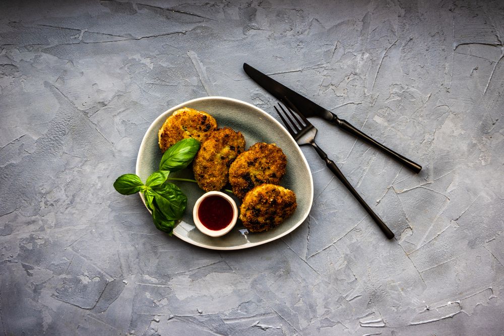 Pork cutlets served with fresh basil and condiment