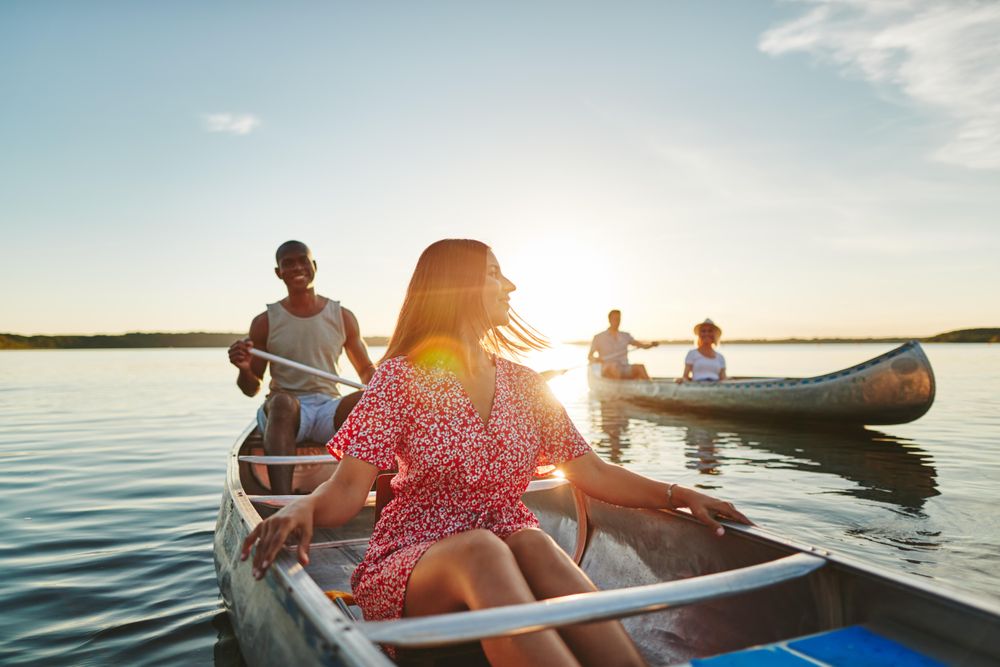 A woman taking a break from paddling on a canoe to enjoy the view