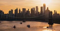 New York City Skyline Aerial Shot from a Helicopter at Sunset. Famous Skyscraper Buildings with Manhattan and Brooklyn Bridges. Busy Diverse Megapolis with Cars, Boats and People Moving Around