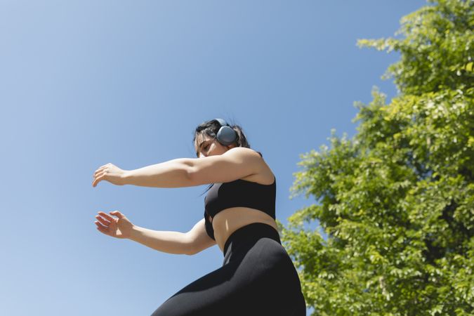 A woman performs arms and leg exercises for a sunny day in Zaragoza, Spain