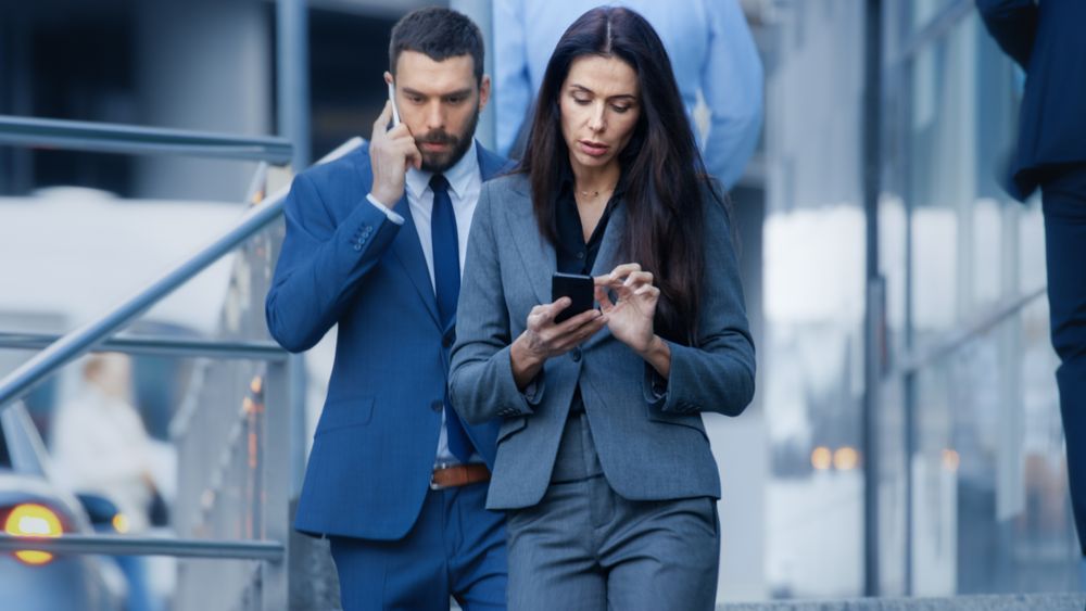 Male and Female Business People Walking on the Big City Business District Street.