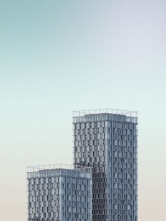 Two textured buildings against a light blue sky