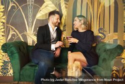 Couple enjoying cocktails on green sofa in bar 5oeDQb
