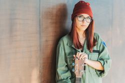 Woman in glasses leaning on wall