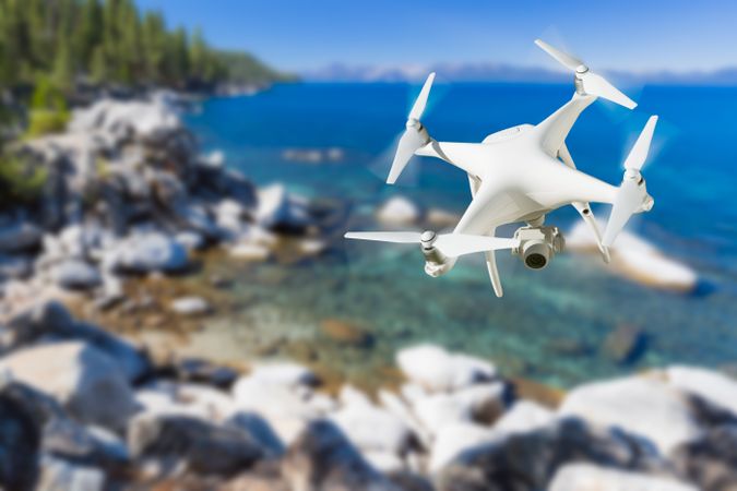 Unmanned Aircraft System (UAV) Quadcopter Drone In The Air Over Lake Tahoe.