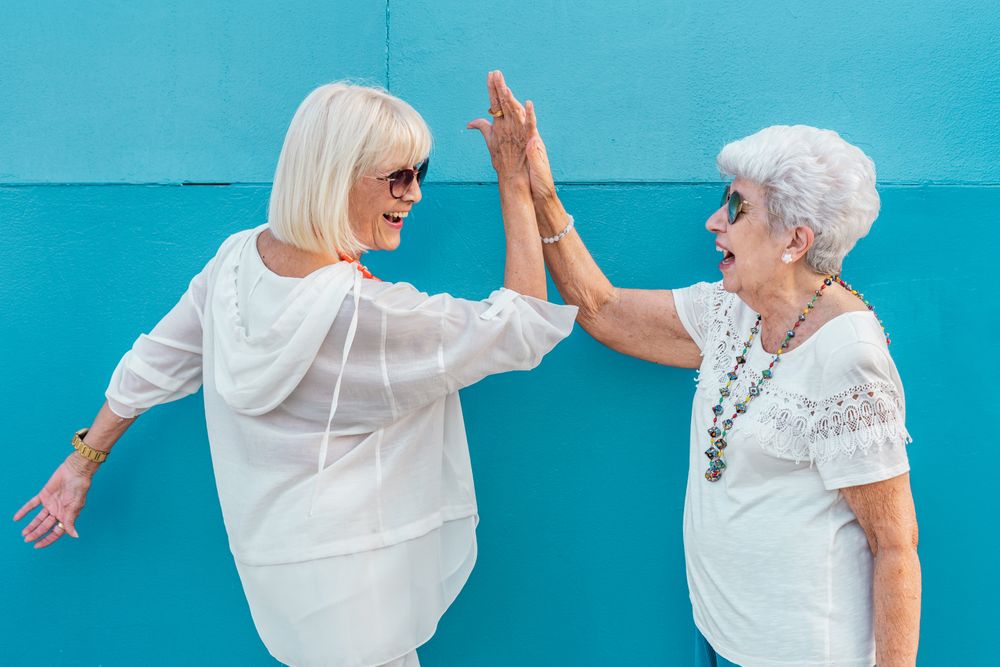 Mature female friends giving high five
