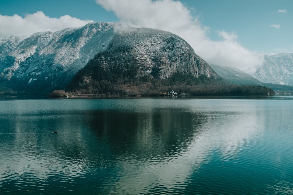 Large snowy mountain surrounded by crystal water