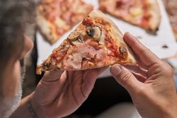 Crop man eating delicious pizza