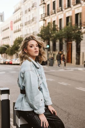 Stylish woman sitting in a bollard