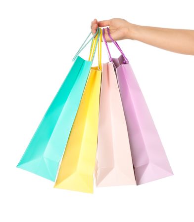 Female hand hold color paper bags isolated on blank background