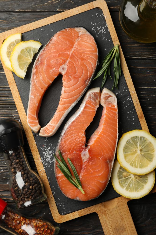 Composition with salmon meat and spices on wooden background, top view