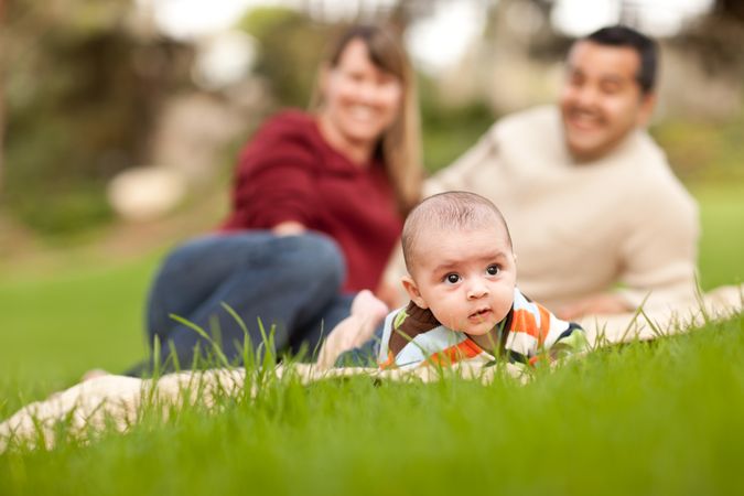 Happy Baby Boy and Parents Playing in the Park