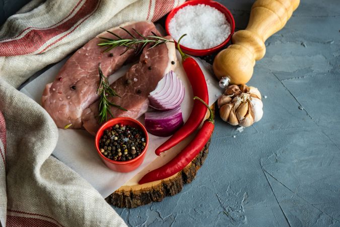 Top view of two raw pork chops with onion, garlic and chili