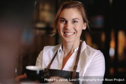 Smiling woman serving coffee inside a coffee shop 4d2gl0