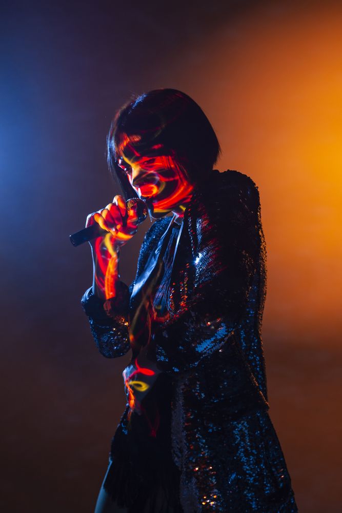 Stylish woman singing on stage