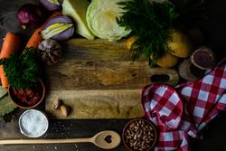 Ingredients for hearty soup surrounding cutting board