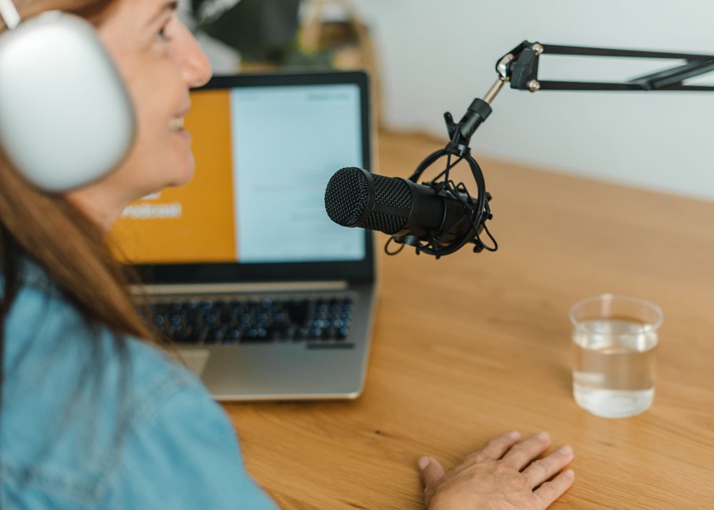 Woman recording podcast at table with mic