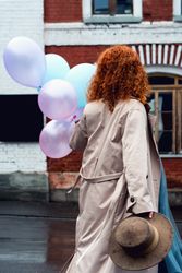 Woman walks streets with bunch balloons