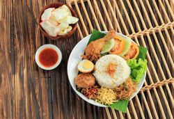 Top view of plate of nasi uduk with rice and chicken