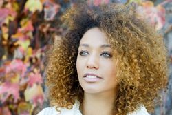 Portrait of wistful woman with fall leaves in background