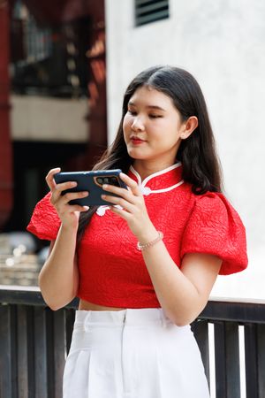 Asian person playing on mobile phone, watching video clip