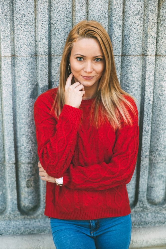 Stylish female standing near marble wall