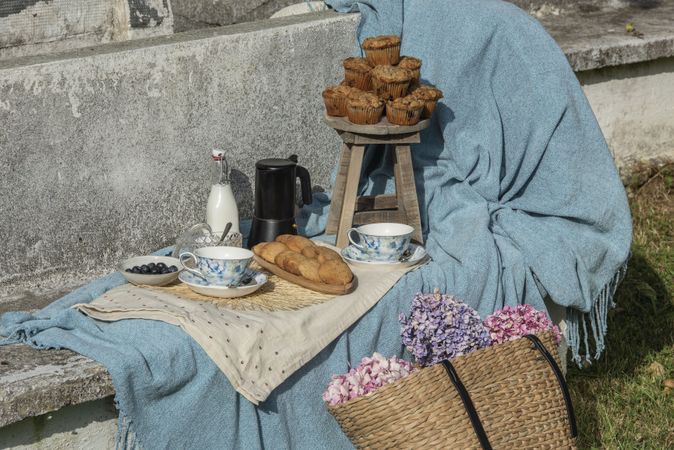 Delicious breakfast with tea and sweets on bench at garden