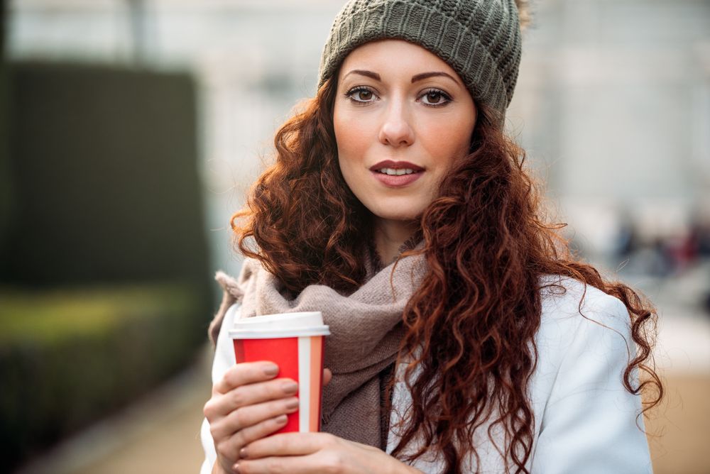 Beautiful woman drinking coffee in the streets of Madrid on winter