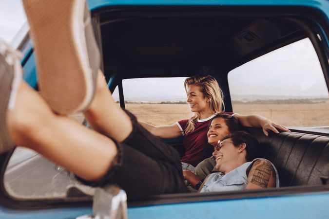 Women friends enjoying traveling by a car
