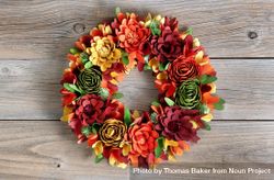 Colorful wreath made of wooden flowers and leaves on vintage wood bDdKEb