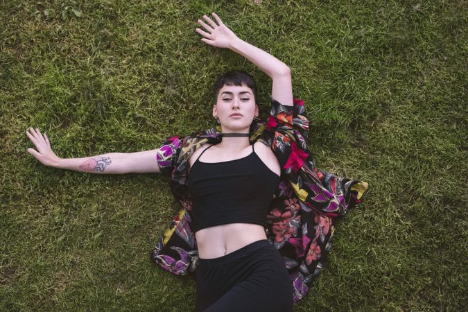 Woman in colored shirt lying on grass
