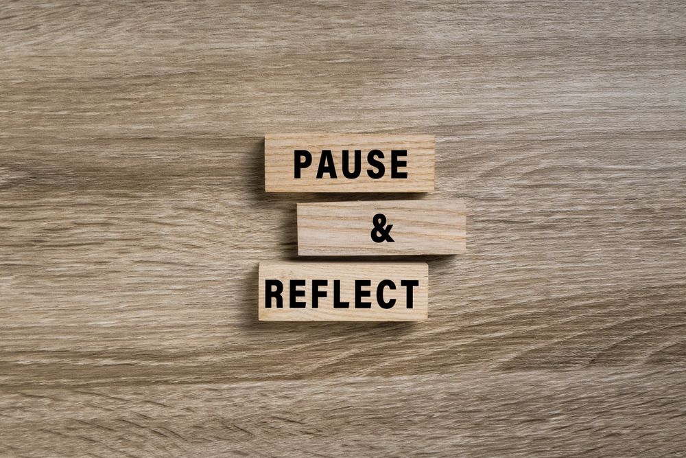pause and reflect words on wooden blocks isolated on wooden background