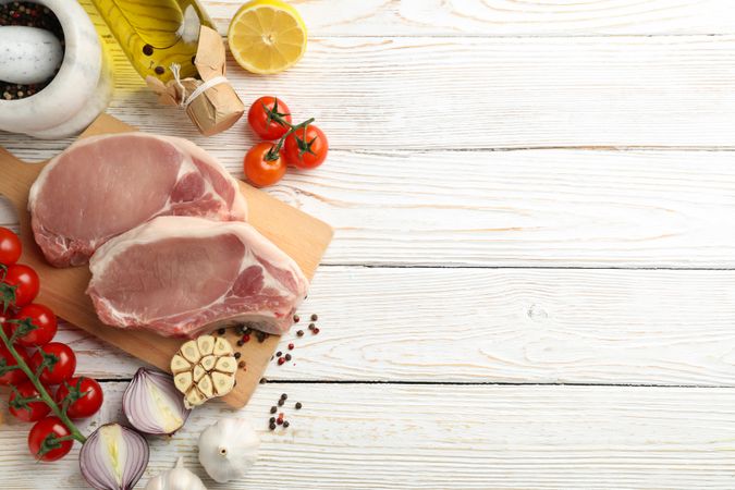 Composition with raw meat for steak and ingredients on wooden background