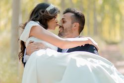 Close up of husband carrying his new wife in forest