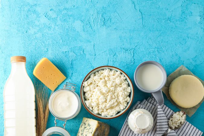 Flat lay composition. Different dairy products on blue background, copy space