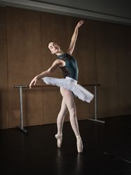 Graceful ballerina standing on tiptoes in pointe shoes