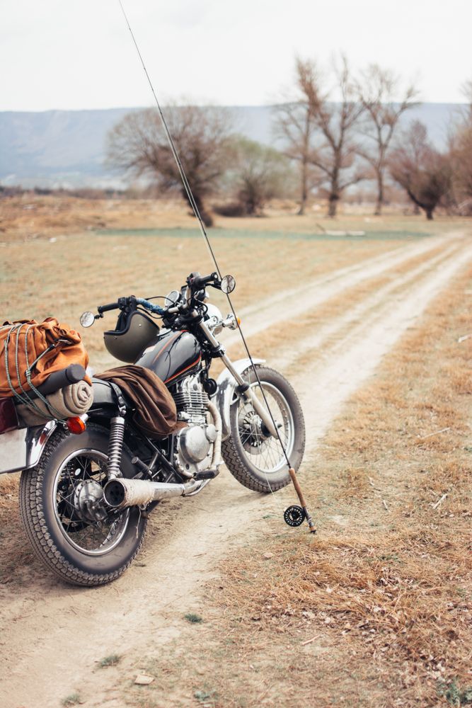 Fishing rod and motorbike on countryside road